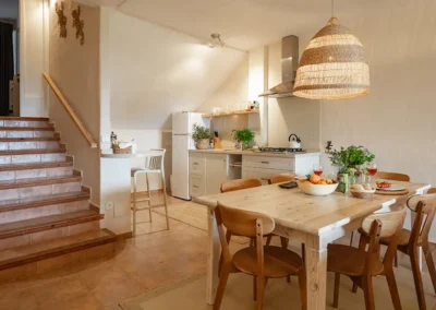 View of the kithenette and dining area with stairs leading up to the bedrooms in Carrasca Family apartment