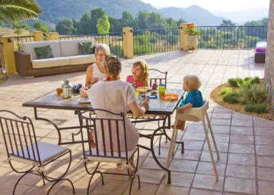 Our family apartments are the perfect place to spend a multi-generational holiday. Here a grandmother, daughter and grandchildren enjoy breakfast on their spacious private terrace overlooing panoramic views over the valley