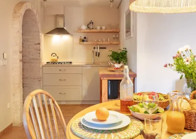 Breakfast is ready at the Palmera family apartment! you can see the kithcnette in the background and the table is laid with fresh fruit, juice, fresh bread and a vase of flowers. There is freshly picked parsley in the kitchen from the kitchen garden herb garden.